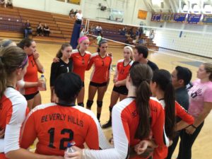 The girls varsity volleyball team reevaluates their strategy in between their games. 