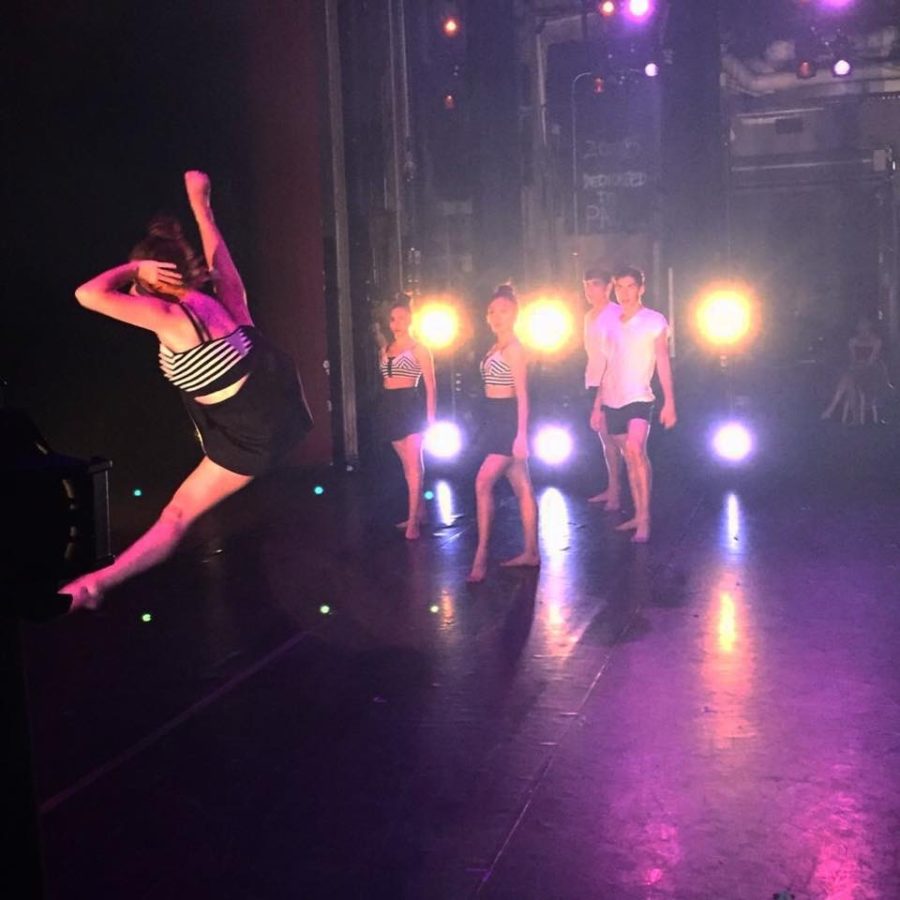Junior Scout Sklarew leaps across the stage as other members of Dance Company look on. Photo courtesy of Rachel Galen