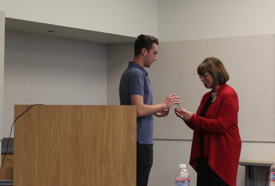 Leanse accepts an award of gratitude from junior Cameron Smith, the president of MSA.