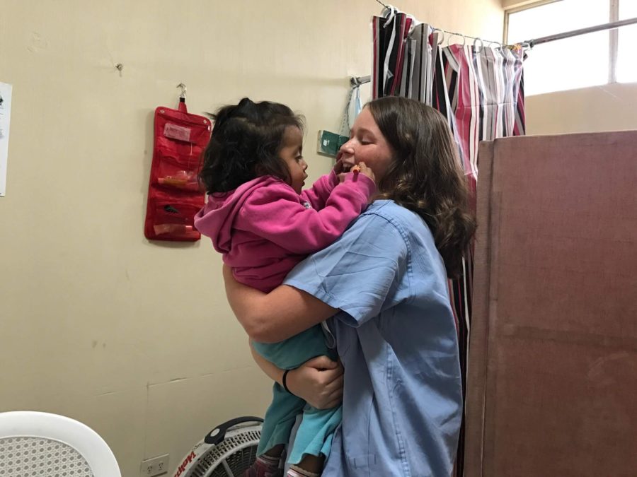 Yaris holds a child while on mission in Guatemala.