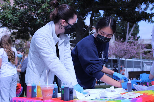 Senior Naomi Jeng and senior Sila Uguz tie-dye their shirts at the in-person ASB Senior Day event on March 25. 