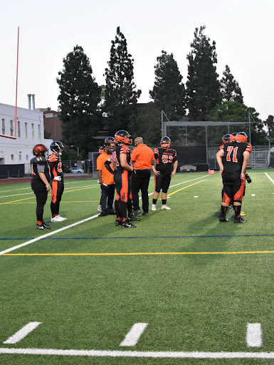 Head Coach, Marquis Bowling gives the Normans instructions as they prepare to face the Verbum Dei Eagles. After about 30 minutes of warming up, the kick-off finally happened at 7.42.
 Photo by: Abby Wolf