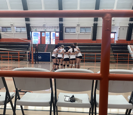 The girls volleyball team gathers for a huddle before the game against Hawthorne. Head Coach Kofi Yankey joined them later on, giving the team their final set of instructions before the whistle. Photo by: Ryo Miyake
