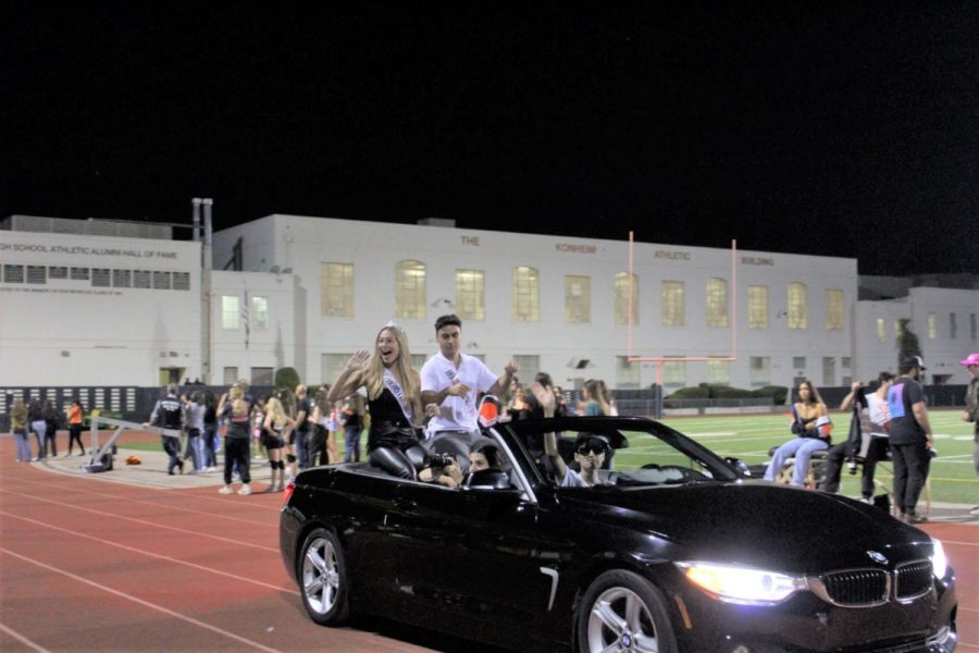 Homecoming+prince+Michael+Larian+and+princess+Amelia+Teschner+ride+around+the+track+in+a+convertible.