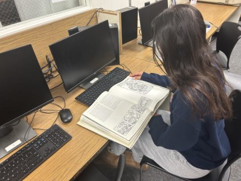 Beverly student  studies with a textbook from the library.
