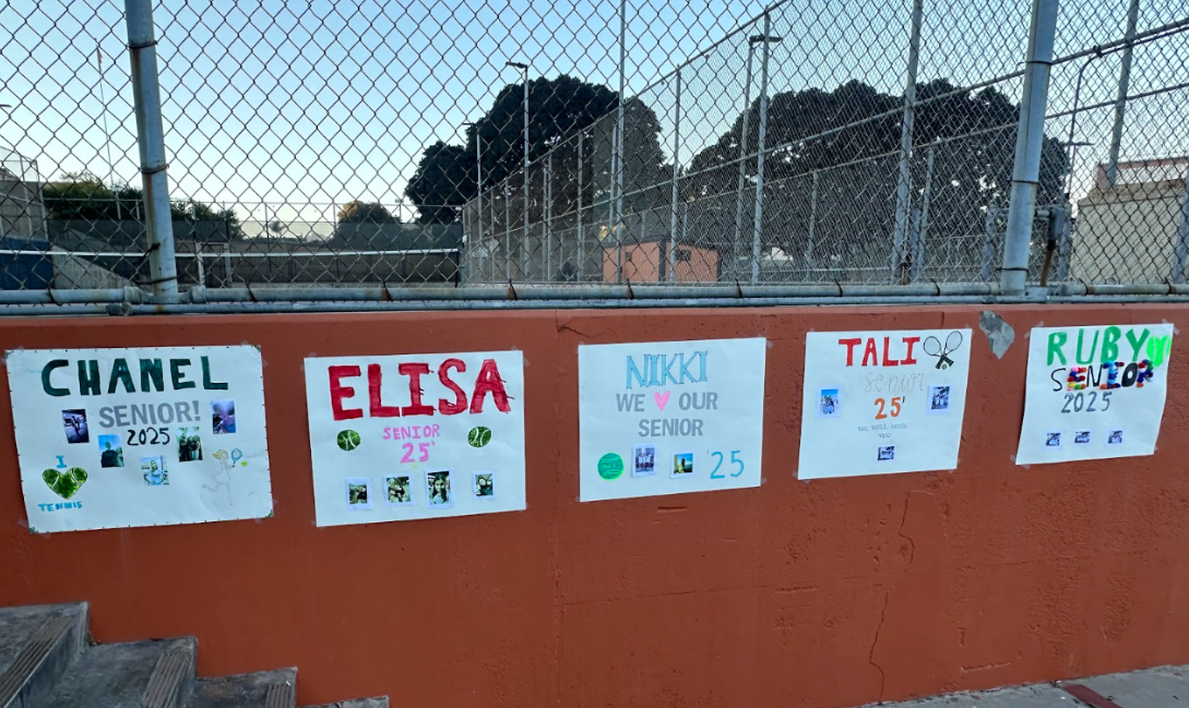 Posters are hung on the tennis court wall for the graduating students on their senior night.