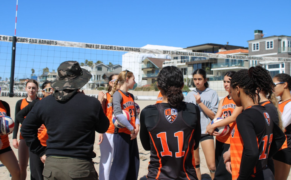 Caption: Coach Martin gives the beach volleyball team a pep talk before their game matches against Mira Costa
