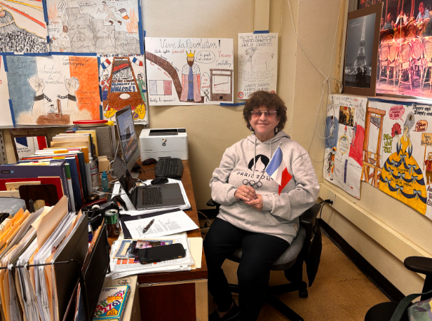 Madame Carson seated happily at her desk.