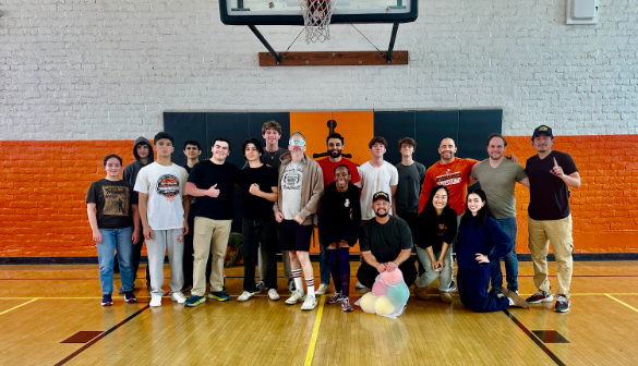 Seniors and teachers huddle for a photo after a fun game of dodgeball.