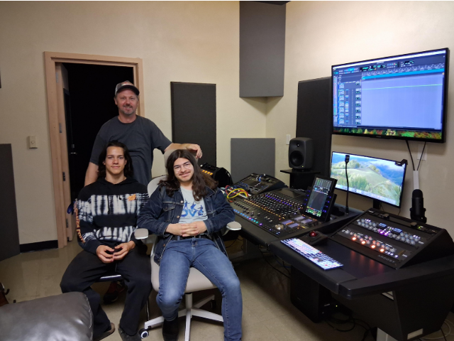 Teacher Alex Brightman, senior Nathan Horowitz and junior Gabriel Longbein next to the school audio mixing console.