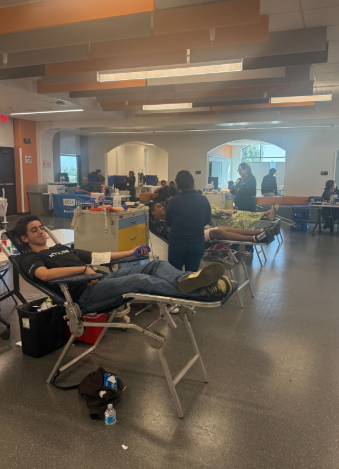 Students donating blood in the media center.