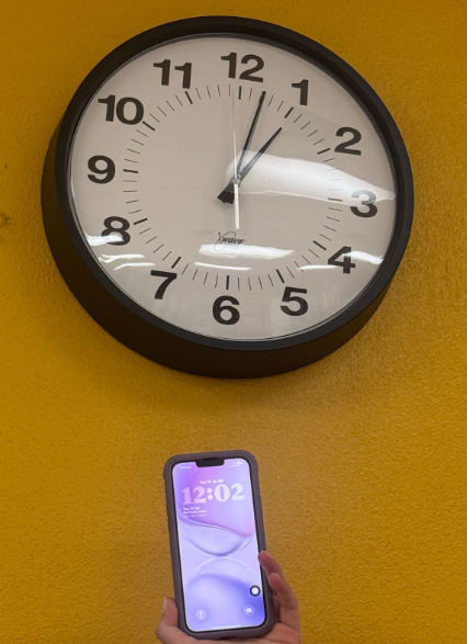 A clock and a phone showing different times due to the time change.