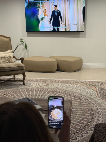 A person uses a phone while watching a movie, which signifies that attention spans are shrinking.
